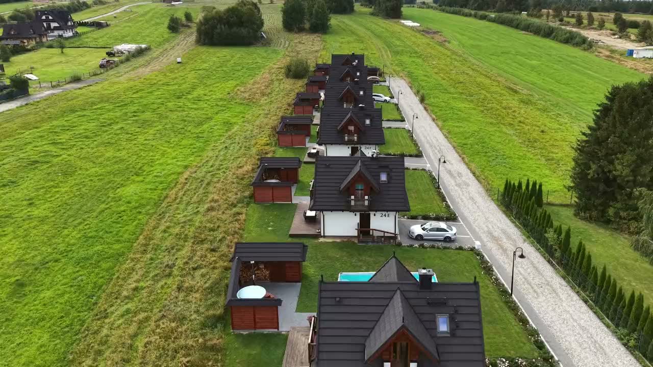 Przelot drona nad rzędem domków Korona Gór wśród łąk w Białce Tatrzańskiej