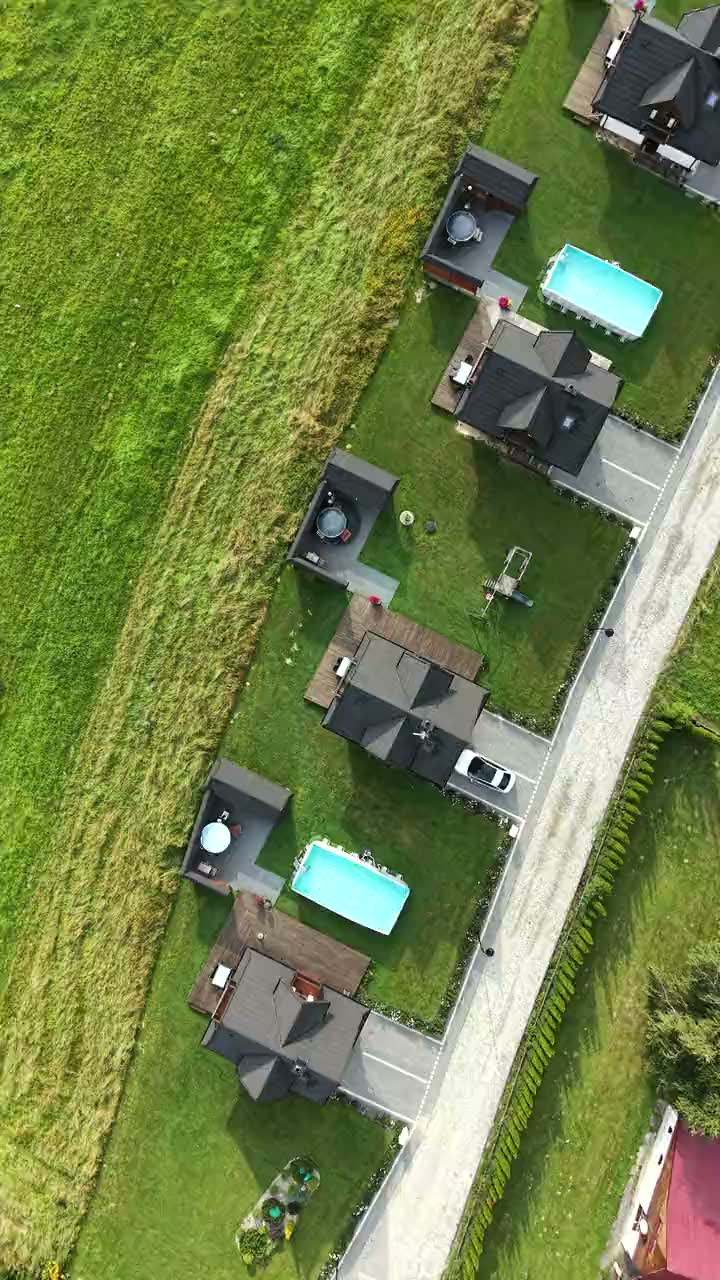 Dron krąży nad domkami Korona Gór: pary domków ze wspólnymi basenami, balie przy tarasach